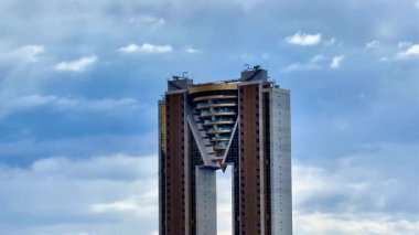 Dramatik bir gökyüzü altında yenilikçi ve eşsiz bir şekle sahip çarpıcı ve görsel olarak büyüleyici bir bina tasarımı.