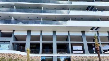 Zarif balkonlar ve şık modern mimari sergilenen çarpıcı, çağdaş bir konut yapısını keşfedin.