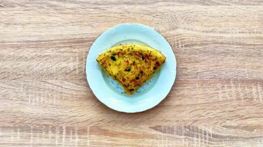 Taze otlar ve baharatlarla kaplı canlı ve pofuduk bir omlet. Günün her öğünü için mükemmel.