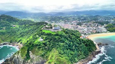 Havadan çekilen canlı tepeler, hareketli şehir ve güzel bir sahil şeridi boyunca altın plaj.