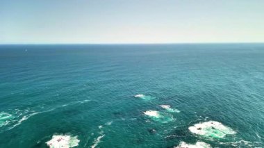 Kayalık kıyılar tarafından çerçevelenmiş uçsuz bucaksız bir su gövdesinin çarpıcı hava görüntüsü. Bu video, sakin yüzeyde yüzen tekneleri yakalıyor, doğayı ve eğlenceyi vurguluyor.