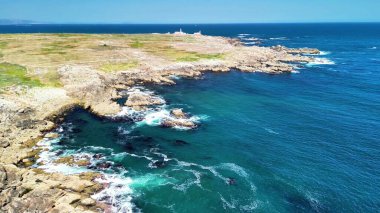 Uçsuz bucaksız okyanusta kayalık kıyı şeritlerinin ve yemyeşil yeşilliklerin çarpıcı manzarasına tanık olun.