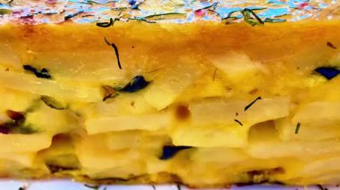 Güzel bir sunum için taze otlar, baharatlar ve renkli süslemelerle kaplı canlı bir patates tortilla.