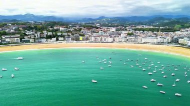 Çarpıcı hava görüntüleri, turkuaz sularda yüzen teknelerle süslenmiş canlı ve resimli bir kıyı şeridi yakalıyor.