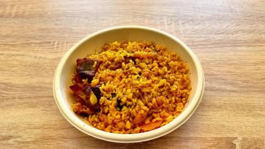 Çeşitli baharatlar ve taze otlarla pişirilmiş canlı ve renkli bir pirinç yemeği, her yemek için idealdir.