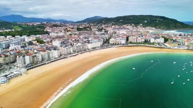 Kesinlikle nefes kesici bir hava manzarası canlı bir plajı ve dağların yakınındaki güzel bir şehri gösteriyor.,