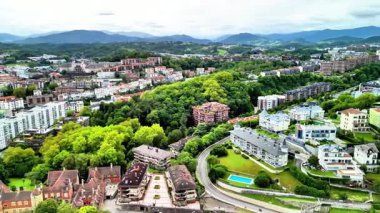 Büyüleyici bir hava manzarası, yemyeşil ve bahçelerle ahenkli bir şekilde çevrili canlı bir şehir mahallesini yakalıyor.