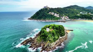 Turkuvaz suları ve güzel bir sahil şeridiyle çevrili harabeleri olan yemyeşil bir adanın çarpıcı hava manzarası.