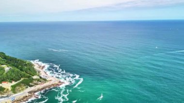Göz kamaştırıcı hava görüntüleri canlı bir kıyı şehrini, altın bir sahili ve yemyeşil bir adayı güzel bir şekilde gösteriyor.