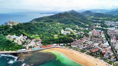 Nefes kesici hava görüntüleri çarpıcı bir kıyı manzarası ve yakınlarda canlı bir şehir manzarası sergiliyor.