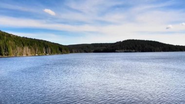 Bereketli yeşillik ve berrak mavi gökyüzü ile çevrili nefes kesen, nefes kesici, el değmemiş bir göl.