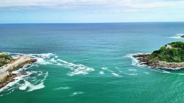 Güzel turkuaz suları ve nazik dalgaları gözler önüne seren nefes kesici kıyı manzaraları.