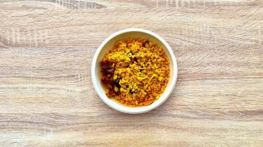 Canlı ve renkli bir kase lezzetli sarı pirinç, çeşitli lezzet ve baharat içeriyor.