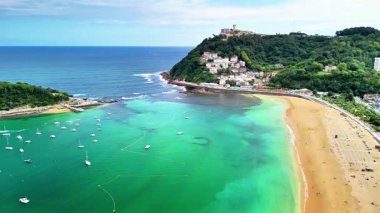 Sersemletici hava manzarası San Sebastins 'in turkuvaz sularını ve kumlu plajı gösteriyor.