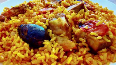 Canlı bir tabak tavuk ve pilav, baharatlar ve taze sebzeler, yemek severler için mükemmel..