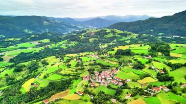 Parlak yeşil tepelere kurulmuş güzel bir köyü gösteren nefes kesici bir hava manzarası yaşayın.