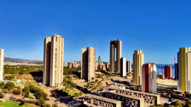 Nefes kesici manzara modern gökdelenleri sergiliyor. Açık mavi gökyüzünün altında kıyı boyunca zarif bir şekilde dizilmiş.