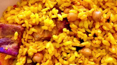 Bu lezzetli yemeğin yumuşak sarı pirinci, nohutu ve taze eti var. Lezzetli bir yemek deneyimi sunuyor.