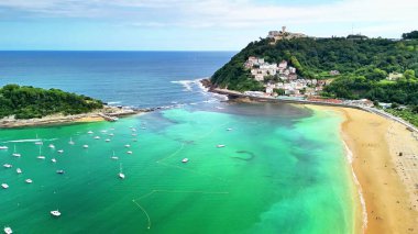 Sersemletici hava manzarası San Sebastins 'in turkuvaz sularını ve kumlu plajı gösteriyor.