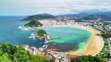 San Sebastins 'in kıyı şeridini ve canlı şehrini gösteren nefes kesici hava görüntüsü.