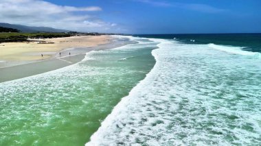 Nefes kesici bir hava manzarası, tam bir rahatlama için ideal, sakin bir sahile çarpan güçlü dalgalar sergiliyor.