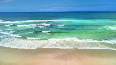 Berrak mavi gökyüzünün altında yumuşak kumlu kıyıların yanında turkuaz suların yer aldığı çarpıcı ve güzel bir sahil.