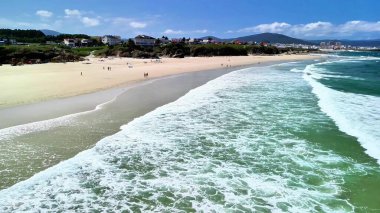 Yumuşak dalgaları ve nefes kesici manzarası olan nefes kesici bir sahil. Rahatlamak ve yaz aktiviteleri için ideal.