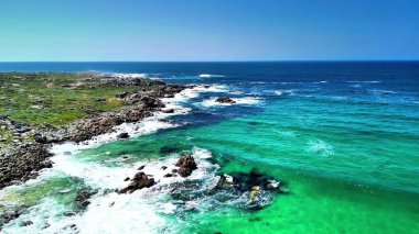 Karanın canlı ve enerjik okyanus dalgalarıyla kusursuz bir şekilde buluştuğu büyüleyici güzellikteki manzarayı yakaladım.