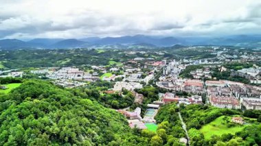 Nefes kesici bir hava manzarası, canlı kentsel gelişimle birlikte yemyeşil bir manzaranın güzelliğini yakalar.
