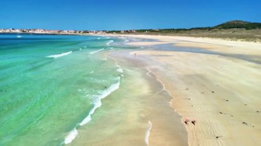 Muhteşem turkuaz suları ve yumuşak, altın kumu olan bir kumsalın nefes kesici hava manzarasını deneyin.