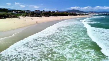 Yumuşak dalgaları ve nefes kesici manzarası olan nefes kesici bir sahil. Rahatlamak ve yaz aktiviteleri için ideal.