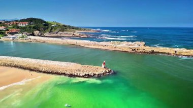 Sersemletici yeşil suları ve kayalık oluşumlarıyla berrak bir sahilin nefes kesici manzarası.