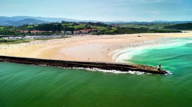 Nefes kesici bir hava manzarası, berrak mavi gökyüzünün altında bir iskeleyi gösteren çarpıcı bir sahil manzarası.