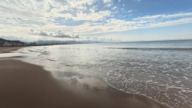 Sakin deniz kenarında kumlu sahil boyunca bir yürüyüş. Yüksek kalite 4k görüntü