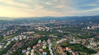 Canlı ve dinamik bir şehir manzarası yakalayan nefes kesici bir hava fotoğrafı. Yeşilliklerle güzelce harmanlanmış.