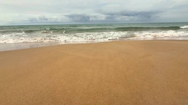 Huzurlu ve sakin bir sahil sahnesi yumuşak dalgaların yumuşak kıyıya vurduğu, gerçekten sakin bir atmosfer yaratan.