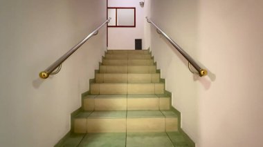 Zarif tırabzanları olan sakin bir merdiven manzarası keşfi teşvik eder ve yukarı doğru hareket etmeyi teşvik eder.