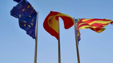 Avrupa, İspanya ve Katalonya 'nın renkli bayrakları güzel bir meltemle mavi gökyüzüne doğru dalgalanıyor.