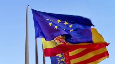 Hem Avrupa Birliği 'nin hem de İspanya' nın dinamik ve renkli bayrakları hafif rüzgarda dalgalanırken görülebilir.