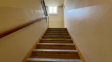 Huzurlu ve güzel bir manzara güzel aydınlatılmış, zarif bir merdiven yukarıdaki parlak bir pencereye götürüyor.