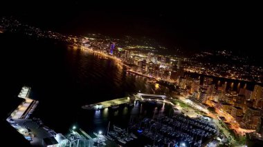 Göz kamaştırıcı bir hava manzarası canlı şehir siluetini ve parıldayan sahil gece hayatını yakalar.