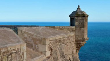 Sakin bir okyanusa bakan tarihi bir kalenin çarpıcı manzarası mimari güzelliğini gözler önüne seriyor.