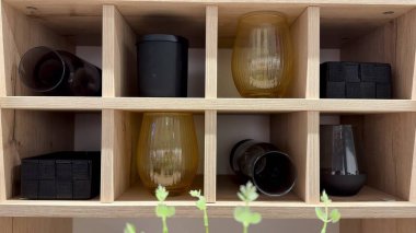 Güzel ekran, ahşap bir rafa düzgünce yerleştirilmiş çeşitli cam ve kaplar içeriyor.