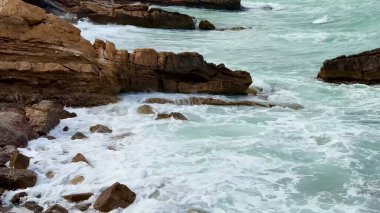 Çarpıcı derecede güzel bir kayalık kıyı şeridi. Çarpıcı dalgalar ve dingin turkuaz suları var.