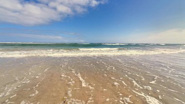 Okyanus dalgalarının getirdiği dindirici sükunetin zevki sıcak, davetkar kıyıya hafifçe çarpıyor.