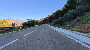 Görkemli dağlarda güzel, dolambaçlı bir yol, göz kamaştırıcı ve nefes kesici doğal manzaralar