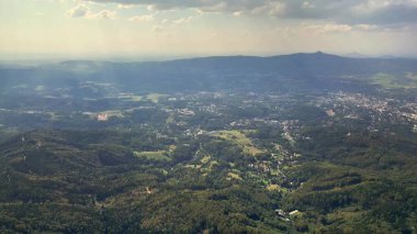 Uçsuz bucaksız ve yeşil bir vadiyi gösteren nefes kesici bir hava perspektifi yuvarlanan tepelerle çevrili.