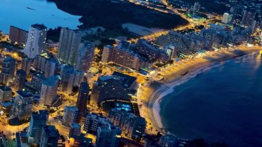 Nefes kesici bir hava manzarası ışıl ışıl şehir manzarasını ve geceleri çarpıcı kıyı şeridini zekice gösteriyor.
