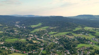 Bu nefes kesen bir hava manzarası. Huzurlu kırsal manzaranın yanında yemyeşil tepeler sergileniyor.