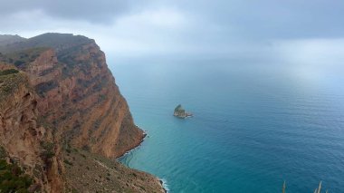 Gök mavisi deniz kıyısında yükselen kayalıkların büyüleyici güzelliğini yakalayın. Doğa ve seyahat temaları için idealdir.